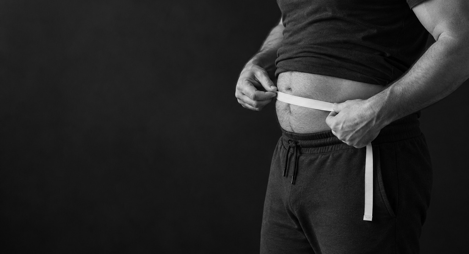Man measuring his waist with a tape measure